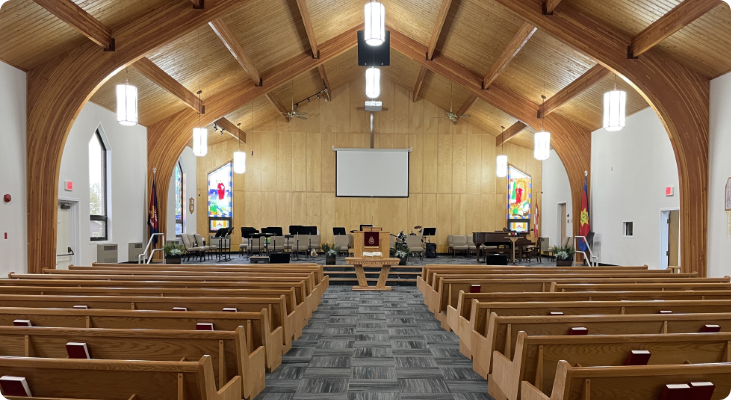 The inside of an empty Gander Church with rows of pews and a projector screen. A place of devotion and faith where congregants gather to worship, pray and find spiritual comfort.
